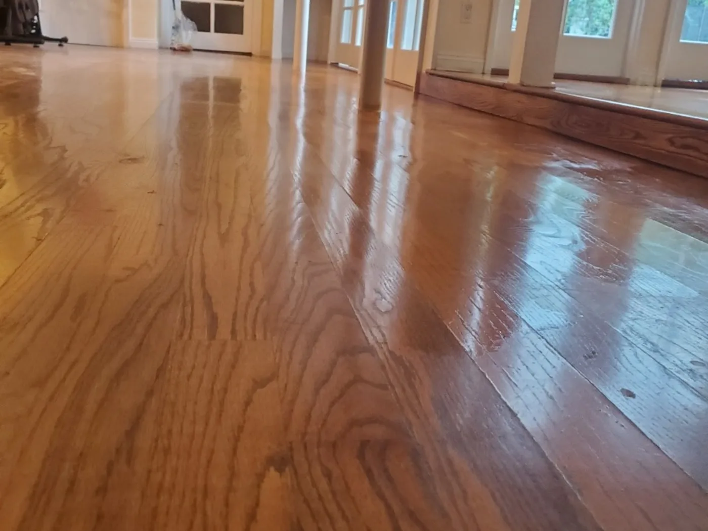 After: The same hardwood sanded and refinished to a deep, even gloss