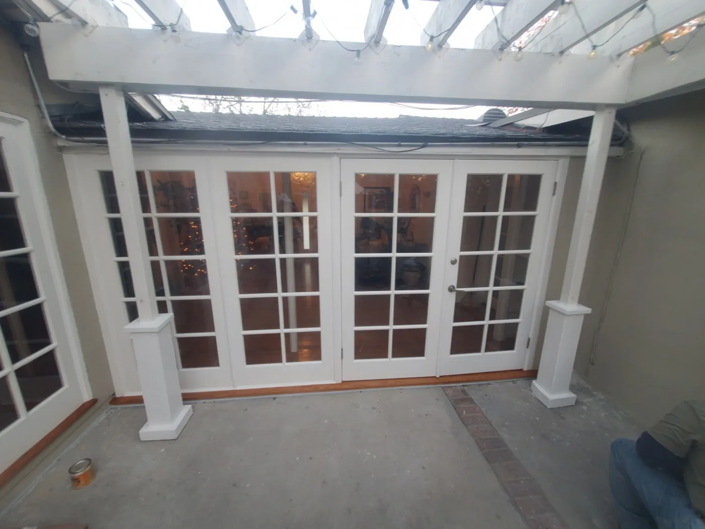 After: The same patio cleaned up with restored white columns and French doors